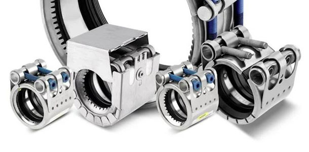 Nahaufnahme von vier unterschiedlichen, glänzenden Edelstahl-Rohrkupplungen auf weißem Hintergrund. Die Kupplungen weisen robuste Konstruktionen mit sichtbaren Schraubverbindungen, Scharnieren, gerippten Innenflächen und schwarzen Dichtungsringen auf. Bla